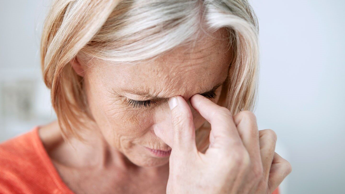 a woman holding her sinuses because of sinus pain