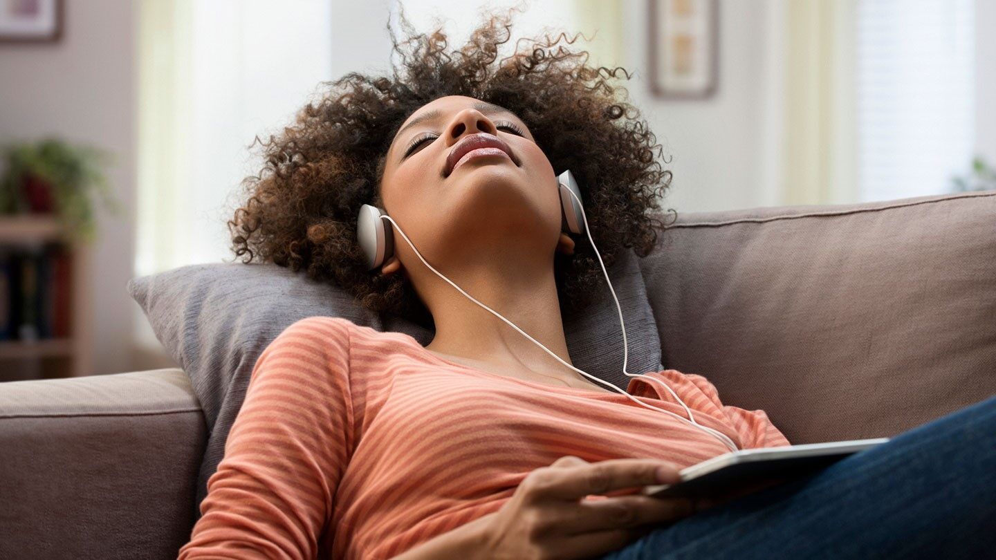 a woman laying down listening to music 